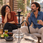Aladin Alux Captain Clear with Ring shisha pipe with an adult couple, flavour and charcoal in a covered veranda setting.