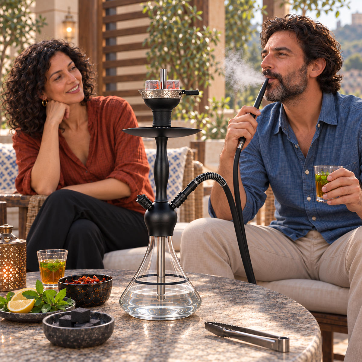 Aladin Alux Captain Clear with Ring shisha pipe with an adult couple, flavour and charcoal in a covered veranda setting.