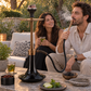Black-glass and bronze Oduman Cosmo shisha pipe in a garden setting with adults and shisha accessories.